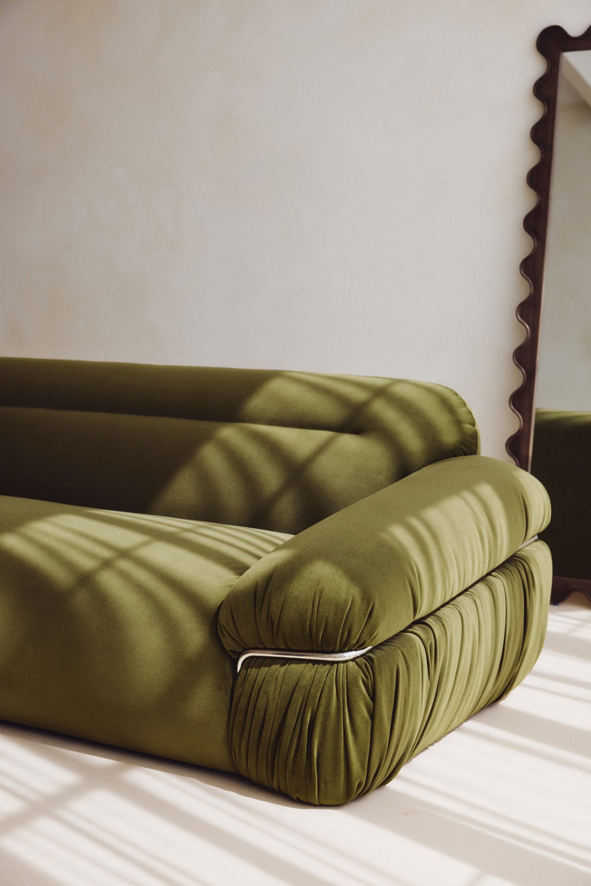 canapé Elea - velours vert mousse - détail accoudoir plissé et liseré chromé lumière rasante