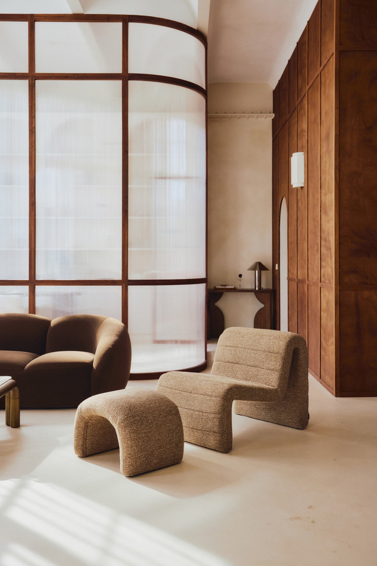 ensemble Flow - fauteuil et pouf tweed marron chêne - vue portrait salon verrière arrondie